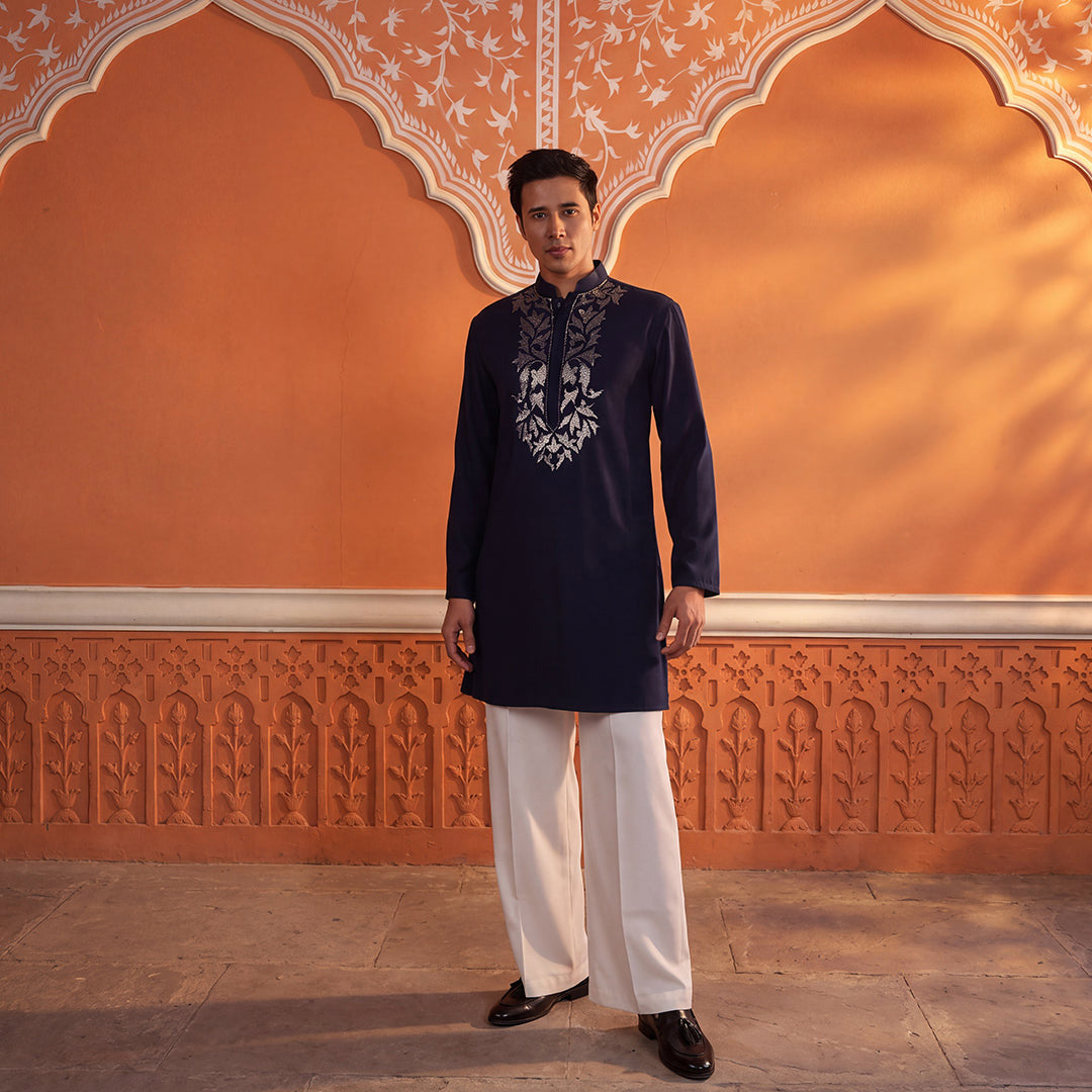 Midnight Aura navy cutdana kurta set with ivory trousers, model against an orange wall