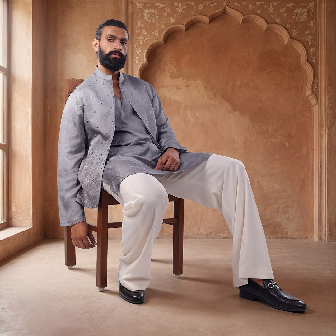 Sky Garden steel grey Nehru jacket set with white trousers, model seated in an arched sandstone set