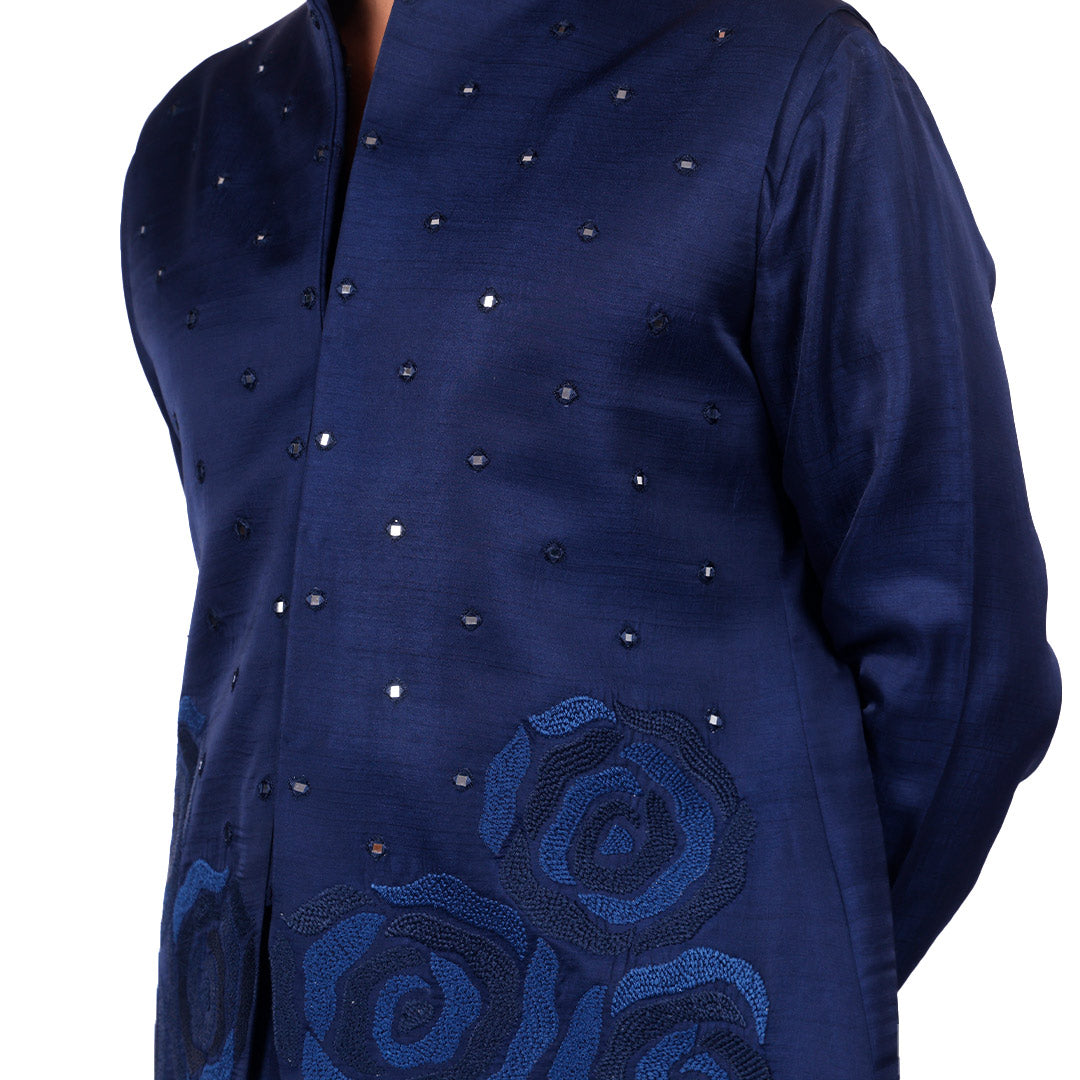 Macro detail of the navy Nehru jacket: scattered mirror dots and tonal rose embroidery near the hem