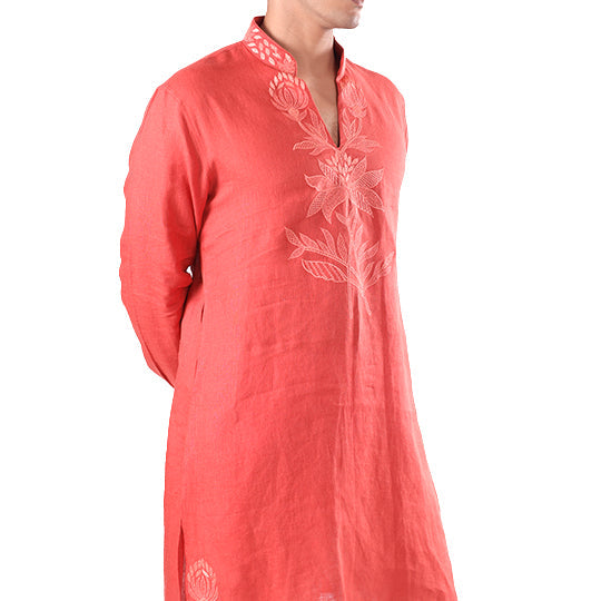 Side view of the coral hemp kurta showing the neckline embroidery and hem motif