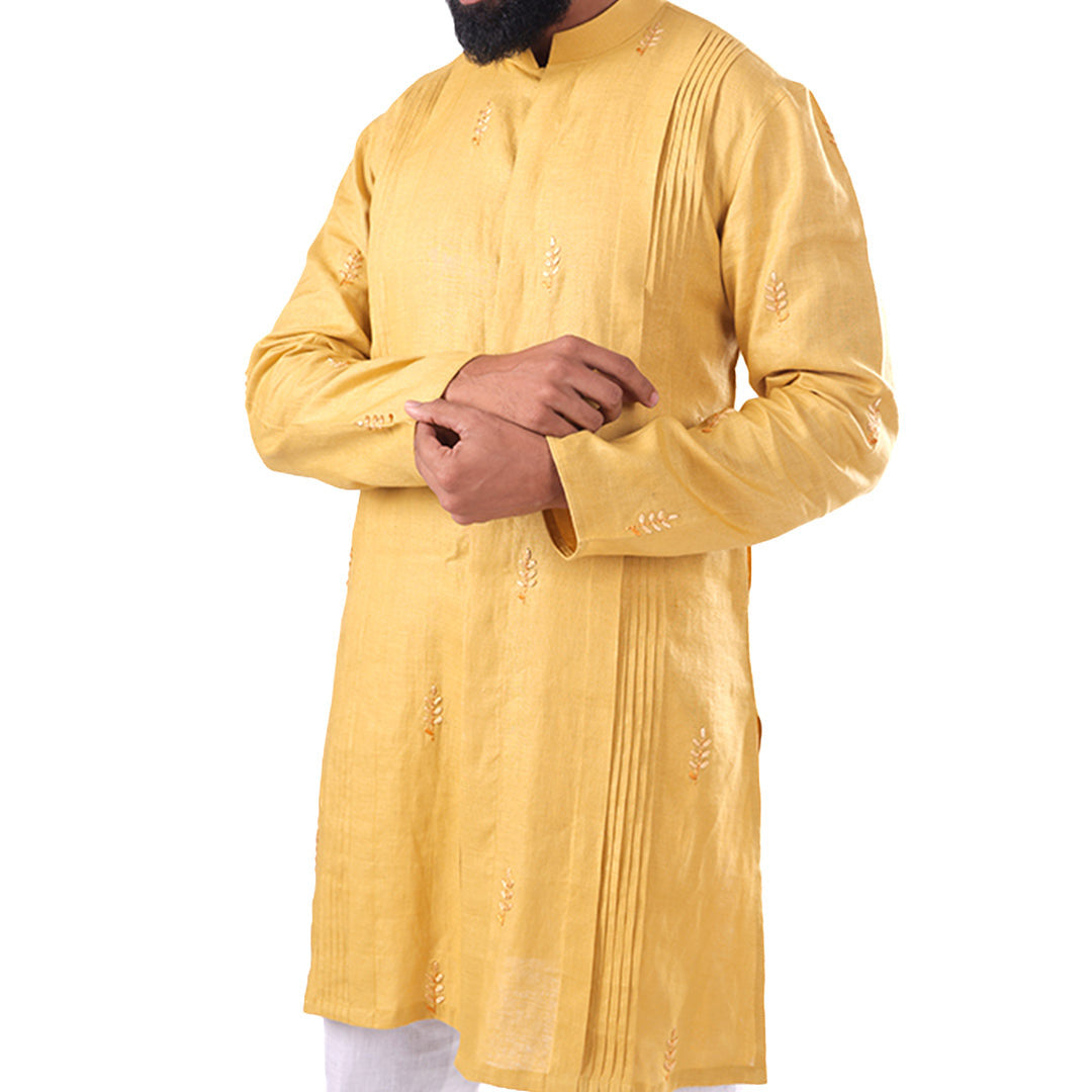 Close view of the marigold hemp kurta showing the pleat columns and thread-work motifs
