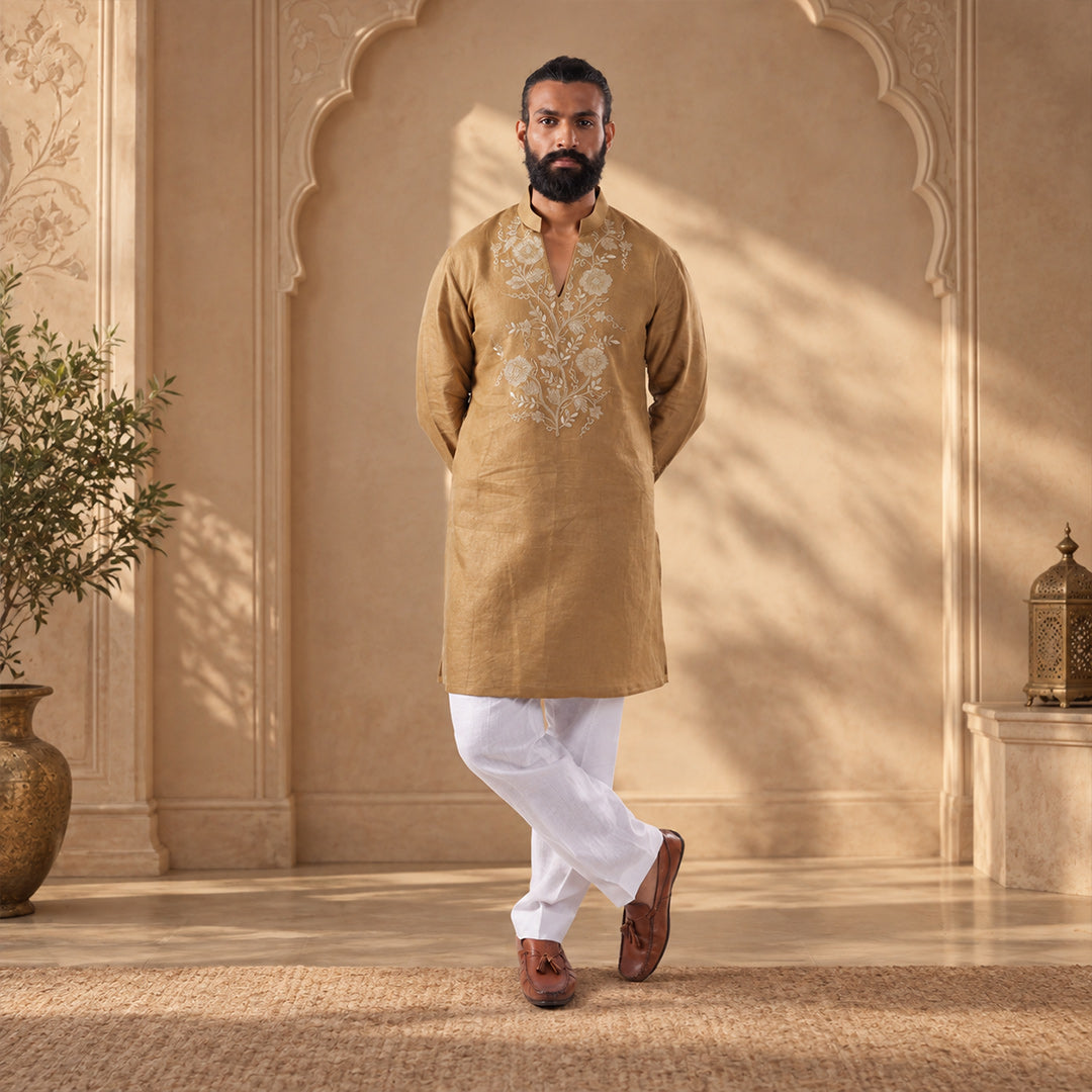 Olive Gold Vine-Embroidered Hemp Kurta Set with white trousers, model in an ivory arched set with an olive tree
