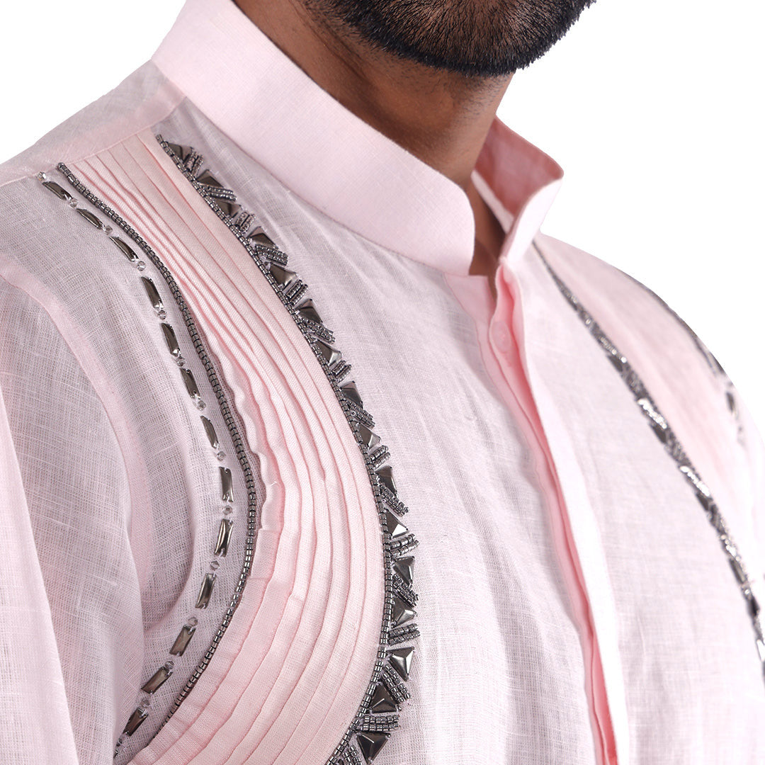 Macro detail of the pink kurta collar, pleated curve and dark embellished trim